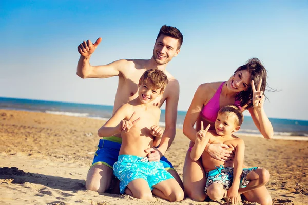 Haqppy giovane famiglia su una spiaggia tropicale — Foto Stock