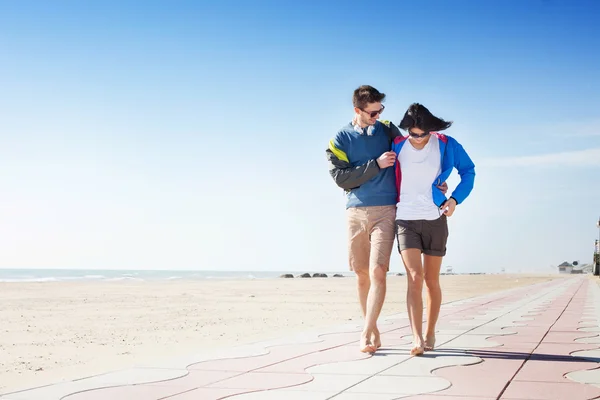 Jeune couple marchant sur une promenade en bord de mer — Photo