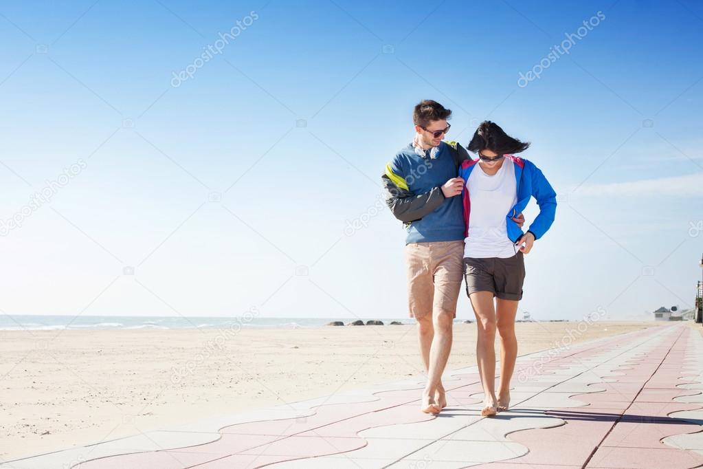 Young couple walking on a seafront boardwalk