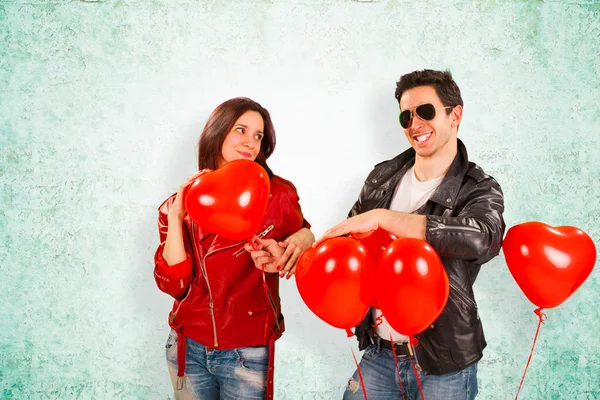 Pareja feliz con globos rojos del corazón — Foto de Stock