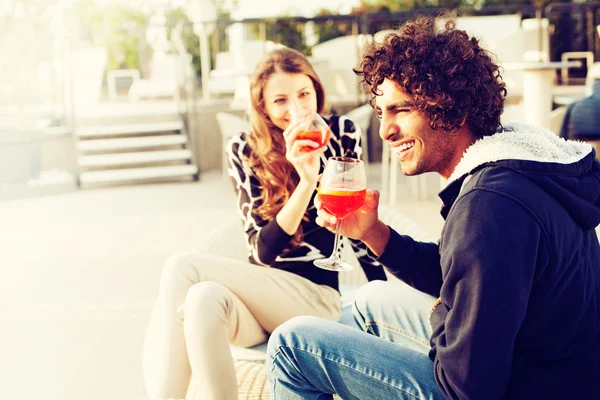 Pareja disfrutando de cócteles y riéndose en el patio —  Fotos de Stock