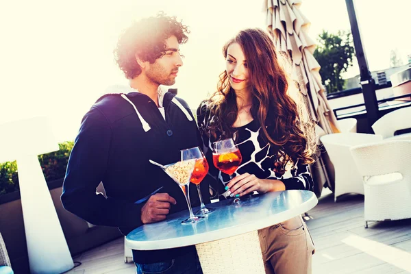 Pareja joven tomando una copa en la mesa al aire libre — Foto de Stock