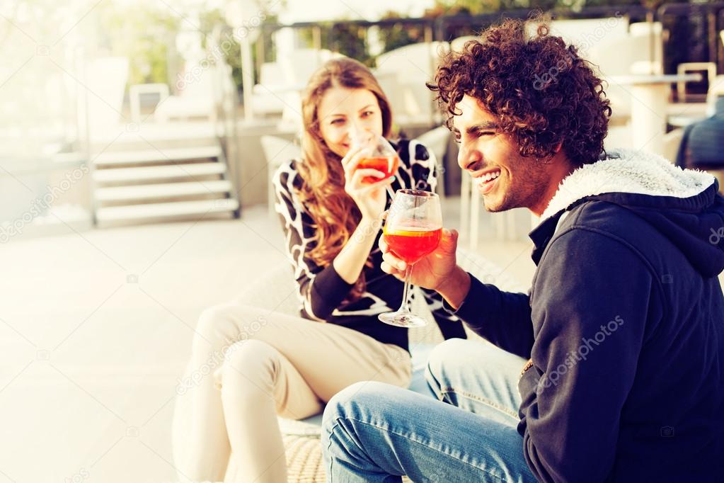 Couple Enjoying Cocktails and Laughing on Patio