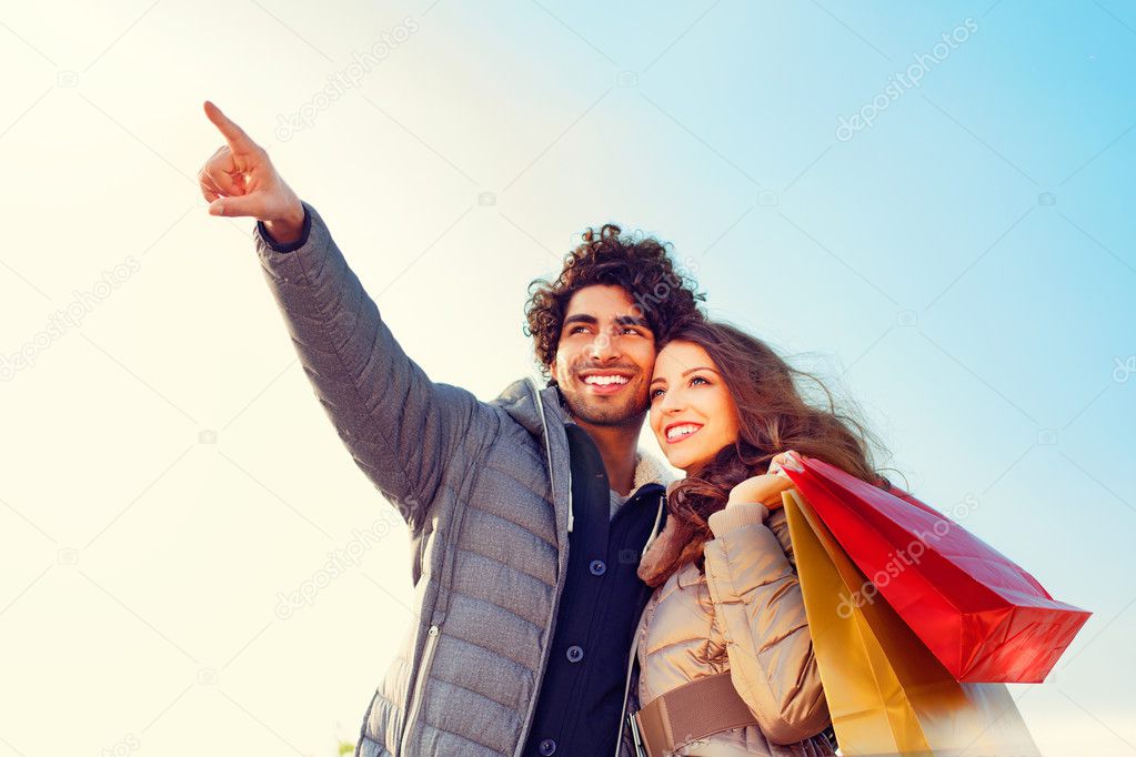 Couple with Shopping Bags Pointing into Distance