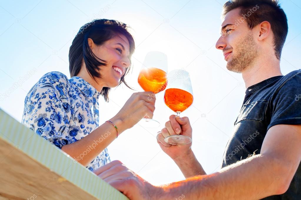 Couple talking while having spritz in a seafront