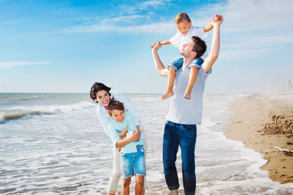Family having fun on the beach to the sea — Stock Photo, Image