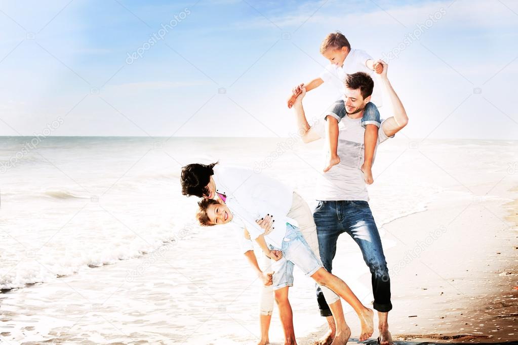 Family having fun on the beach to the sea