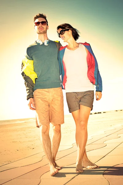 Romantic Young tourist couple standing on a beach at sunset — Stock Photo, Image