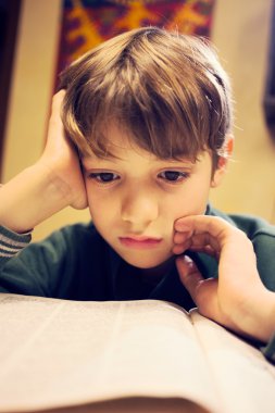 Genç bir çocuk üzerinde ödev konsantre.