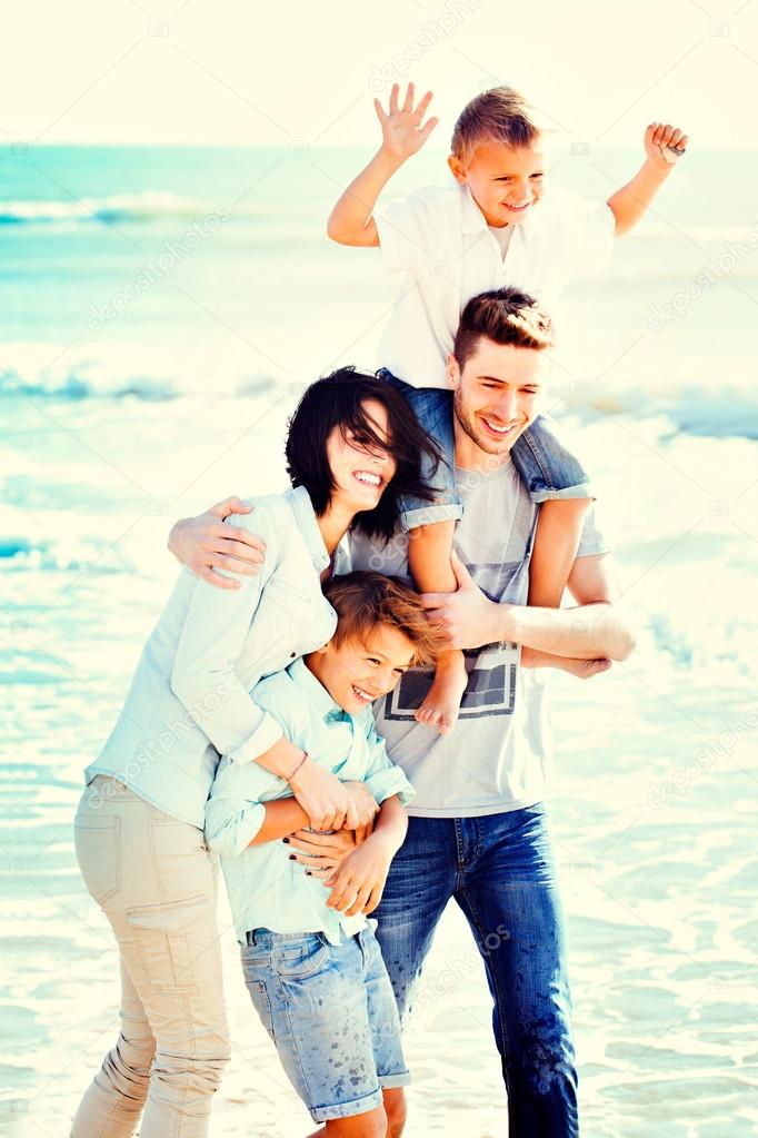 Happy Small Family Having a Vacation at the Beach During Summer.