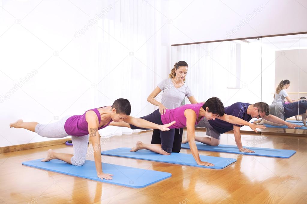 Teacher explaining people fitness exercises to balance the body