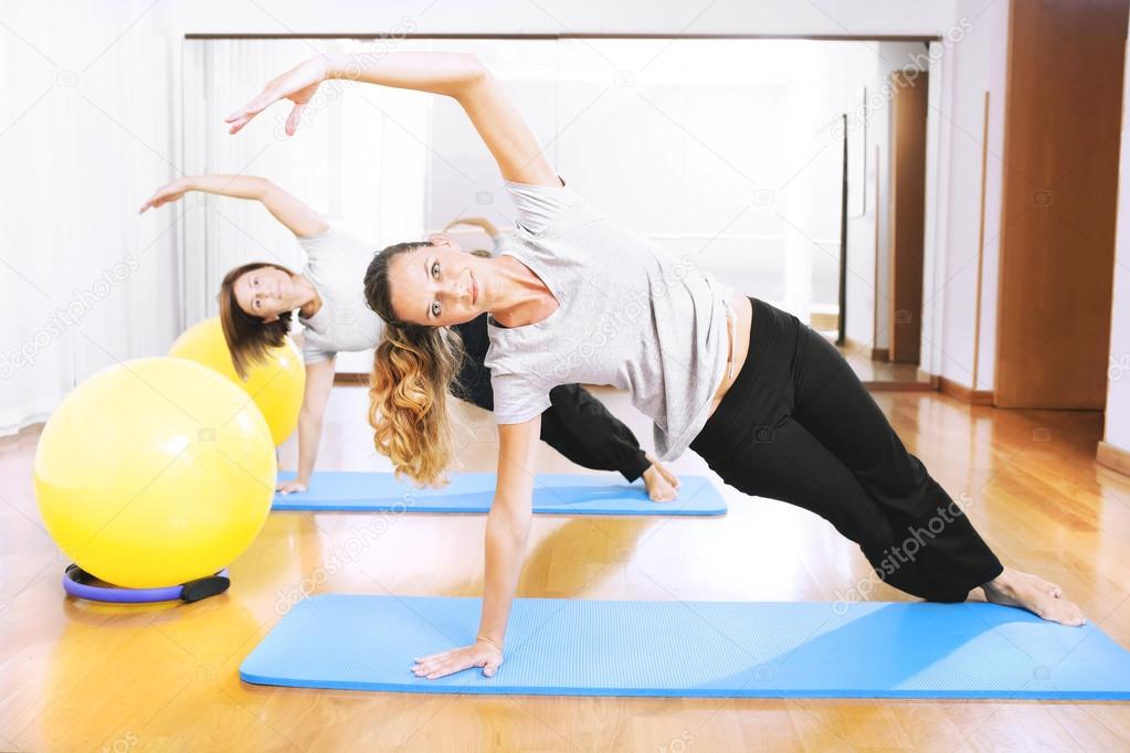 Two women making a fitness exercisen in synchrony
