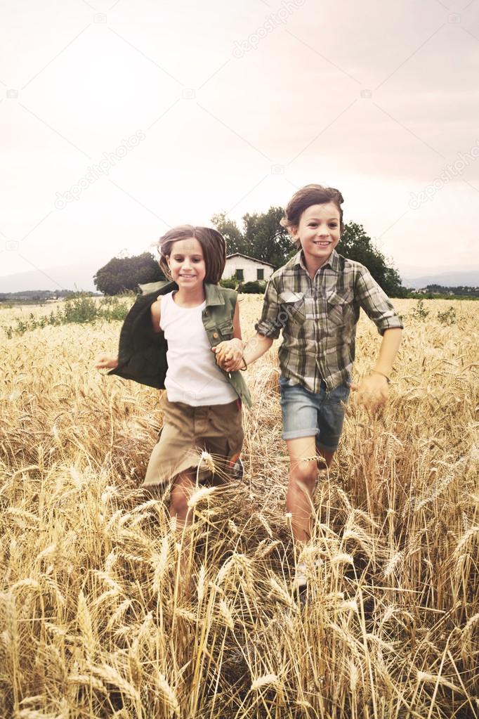 young boys  running in the wheat field