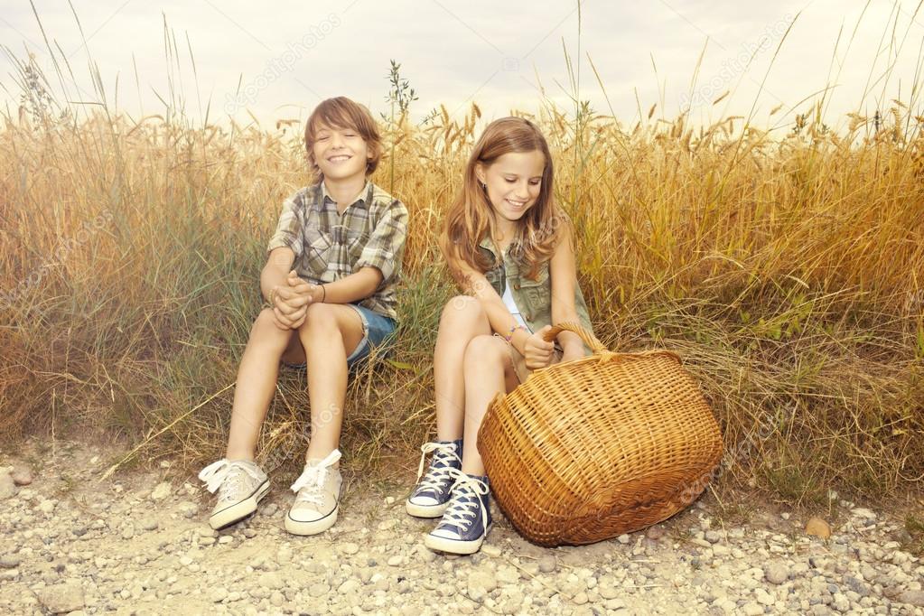 Friends picnicking together in a field of wheat