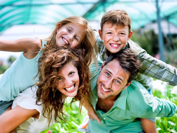 Szczęśliwa rodzina pozuje do zdjęć w szklarni — Zdjęcie stockowe