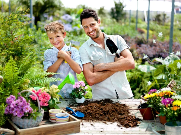 Father and son playing with work tools in a greenhouse — Stock Photo, Image