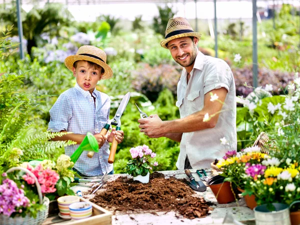Far och son leker med arbetsredskap i ett växthus — Stockfoto