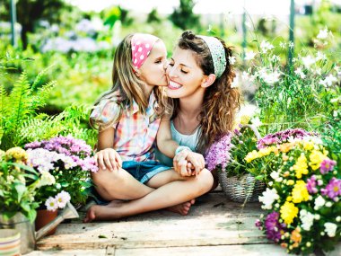 Mom and daughter have fun in the work of gardening clipart