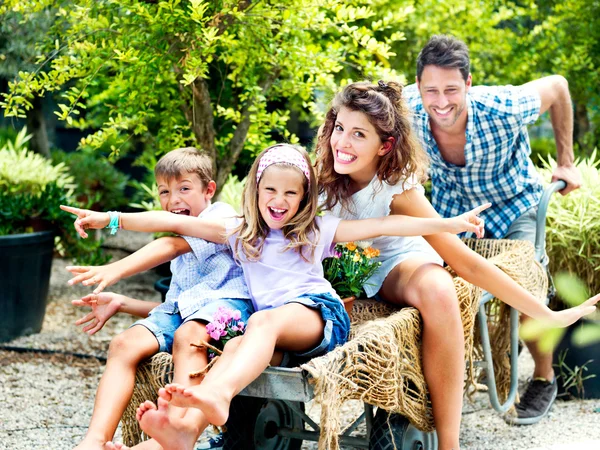 Familjen har roligt med en gravhög i ett växthus — Stockfoto