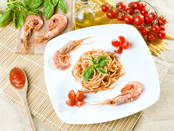 Mediterranean kitchen, spaghetti, shrimp, tomatoes, basil and oil — Stock Photo, Image