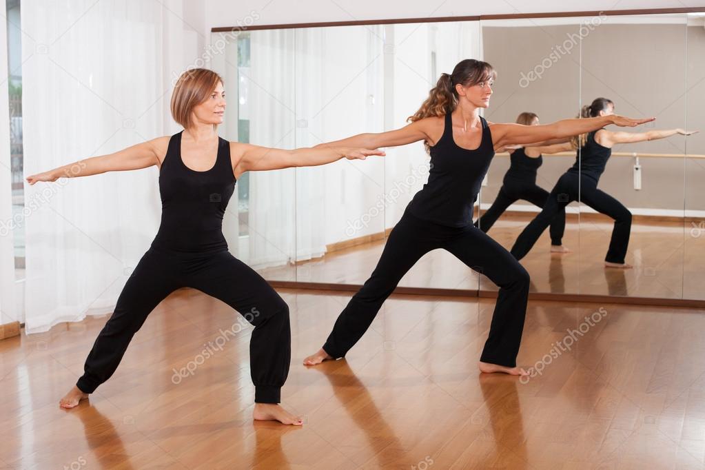 Two women making a fitness exercises in synchrony