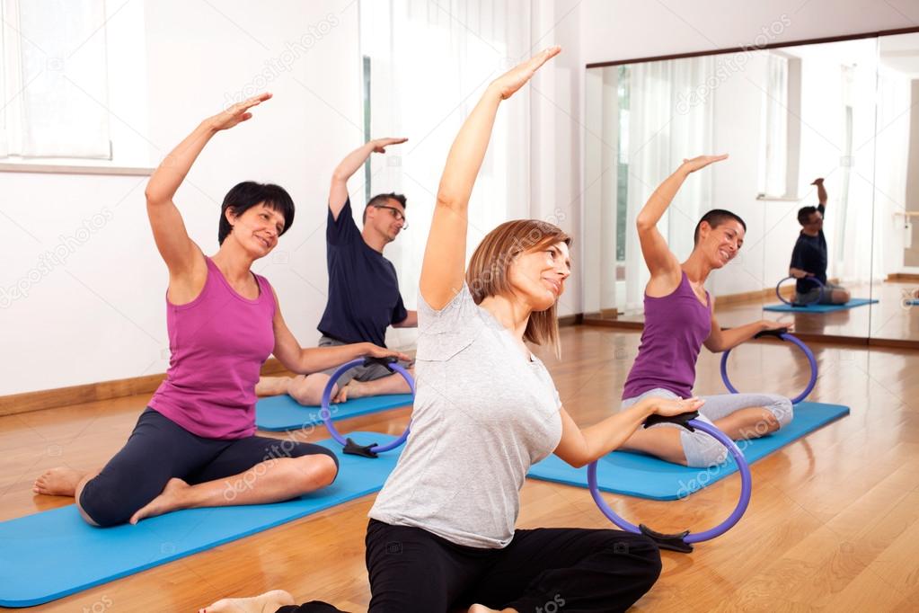 Group of people copying fitness exercise by the teacher