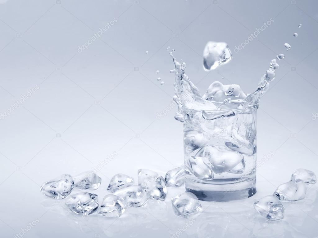 Ice cubes falling into a glass of water