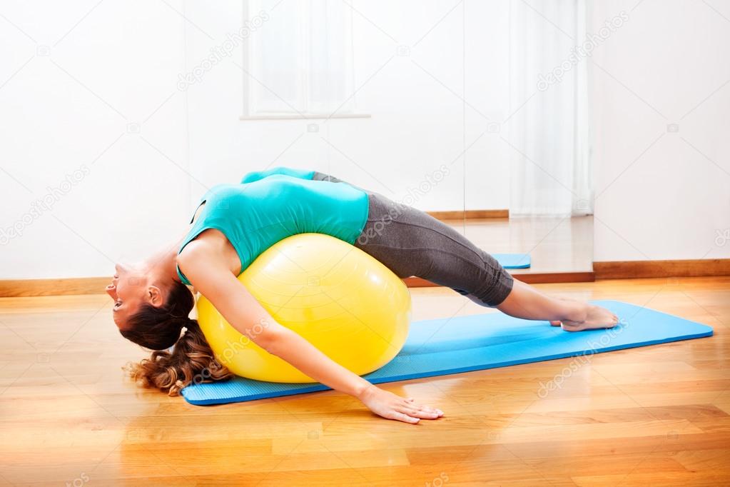 Teacher making body exercises on a yellow ball