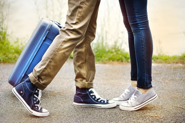 Benen van twee geliefden ontmoeten met koffer — Stockfoto