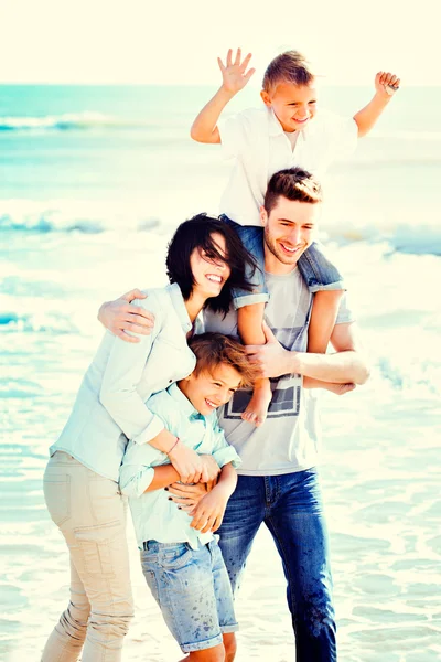 Felices pequeñas familias teniendo unas vacaciones en la playa durante el verano . — Foto de Stock
