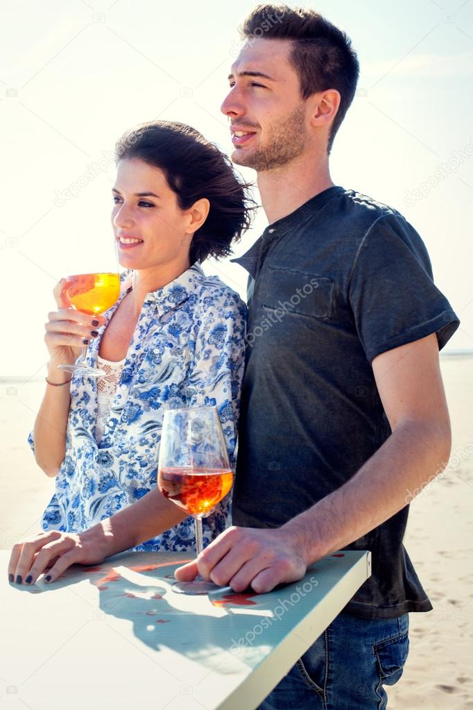 Couple relaxing while having spritz in a seafront