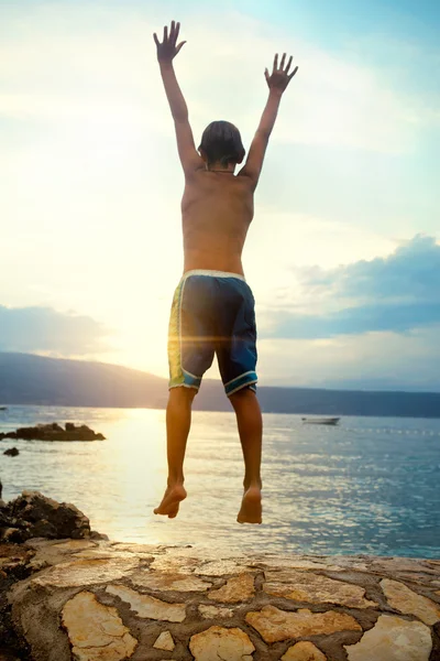 Niño saltando y respirando profundamente al atardecer — Foto de Stock