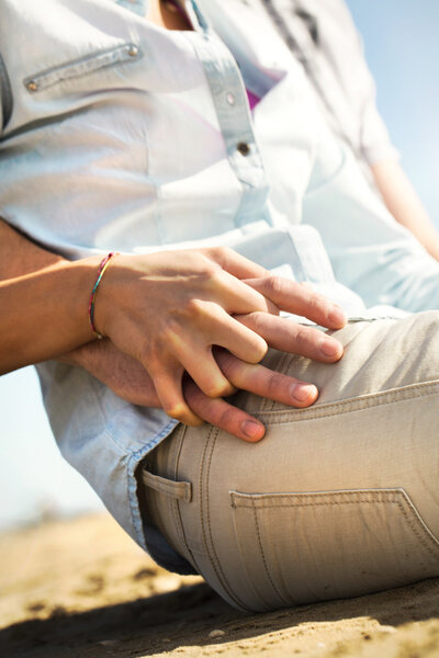 Couple holding hands on the beach to the sea