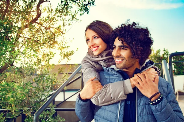 Casal sorridente com braços ao redor uns dos outros fora — Fotografia de Stock