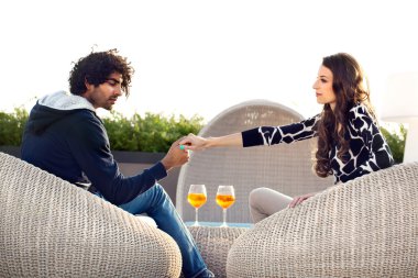 Couple holding hands while drinking an aperitif clipart