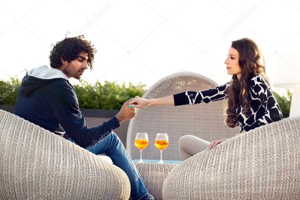 Couple holding hands while drinking an aperitif