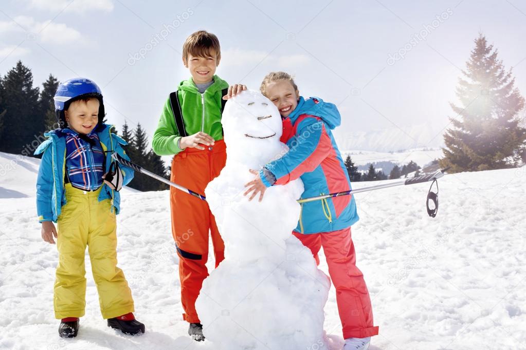 brothers and sister  building a snowman