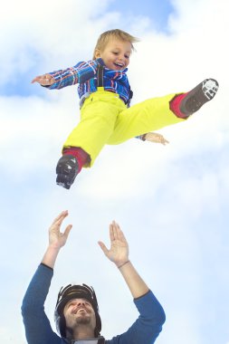 Father launching his son up in to the sky clipart