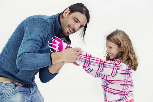 Pappa hjälper dottern kärleksfull att bära handskar — Stockfoto