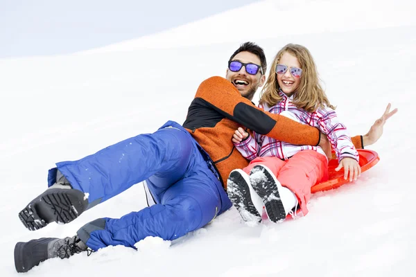 Meisje en zijn vader rodelen zeer snel in montain — Stockfoto