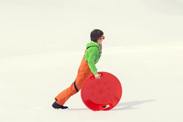 Joven chico divirtiéndose con su bobsled — Foto de Stock