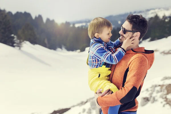 Pappa bär sin son till härlig vinter landskap — Stockfoto