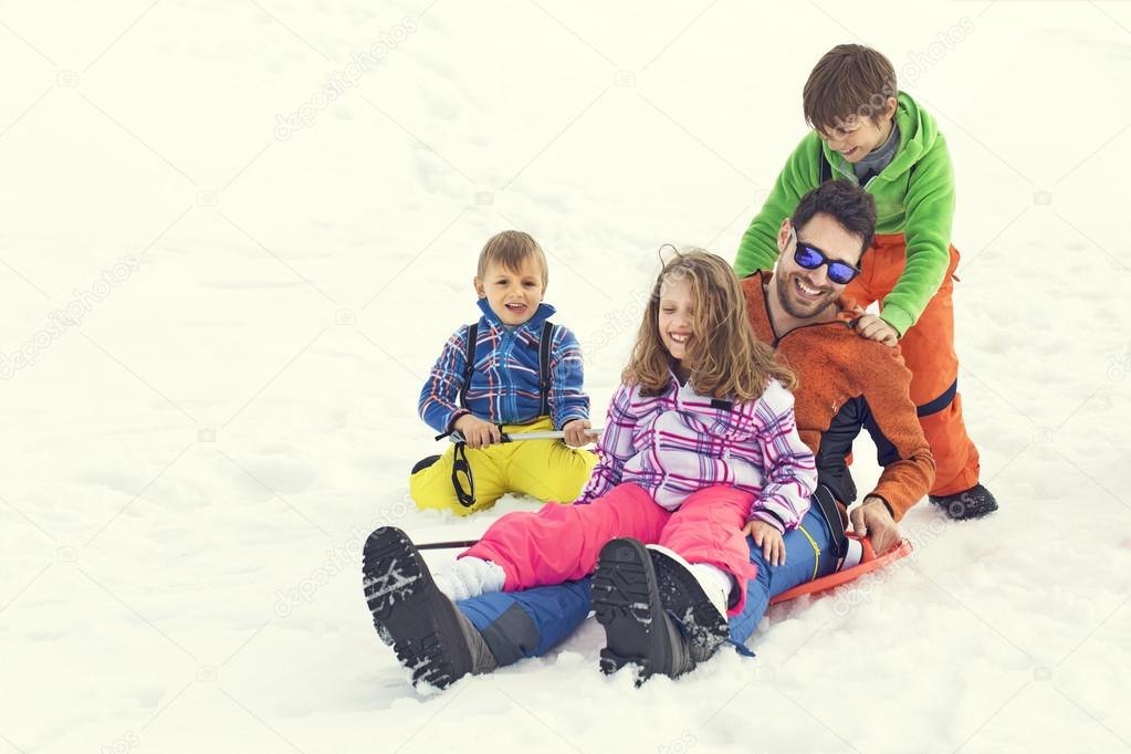 Father having fun in the snow with his children