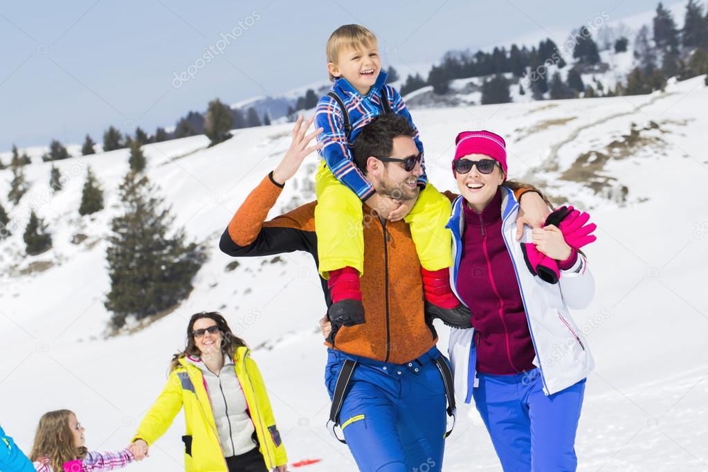 Two families with children walking in the snow 
