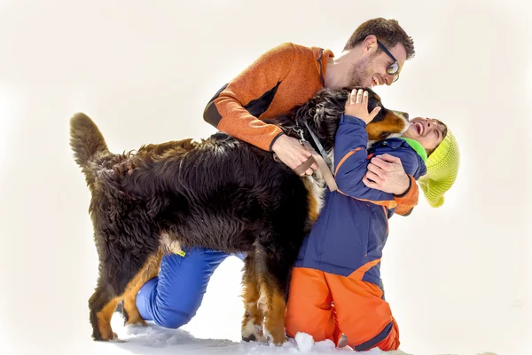 Pai, filho e seu cão se divertindo na neve — Fotografia de Stock