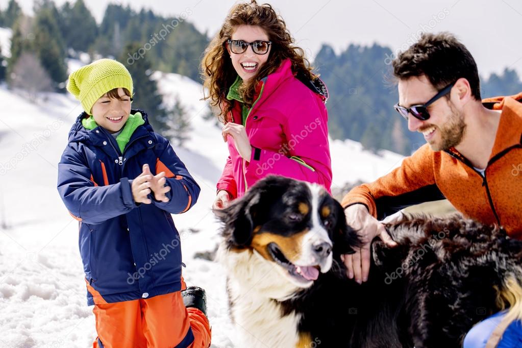 Family with dog having fun in the snow