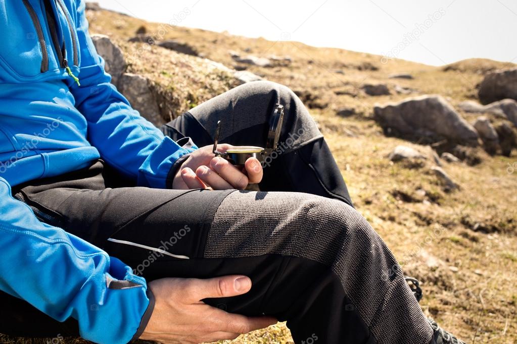 Man seeks direction with the compass in the mountains
