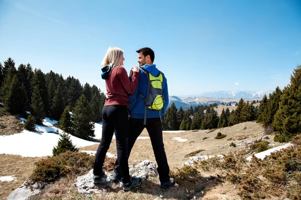 Dois caminhantes com mochila em pé no topo da montanha — Fotografia de Stock