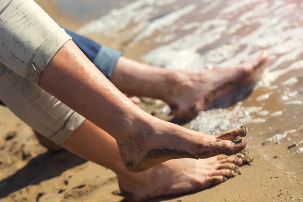 Par de pies salpicando en el agua al mar — Foto de Stock