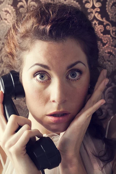 Έκπληξη νεαρή γυναίκα στο τηλέφωνο στο καθιστικό στα αγγλικά της — Φωτογραφία Αρχείου